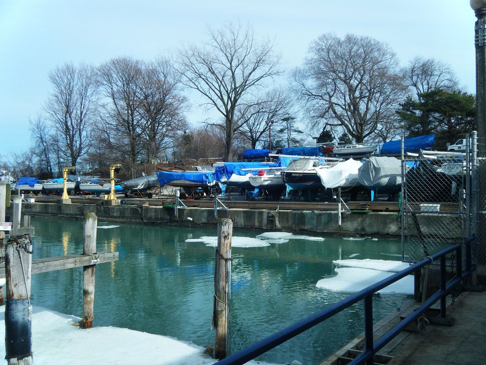 Boats covered and stored on land for the winter at a lake harbor.
