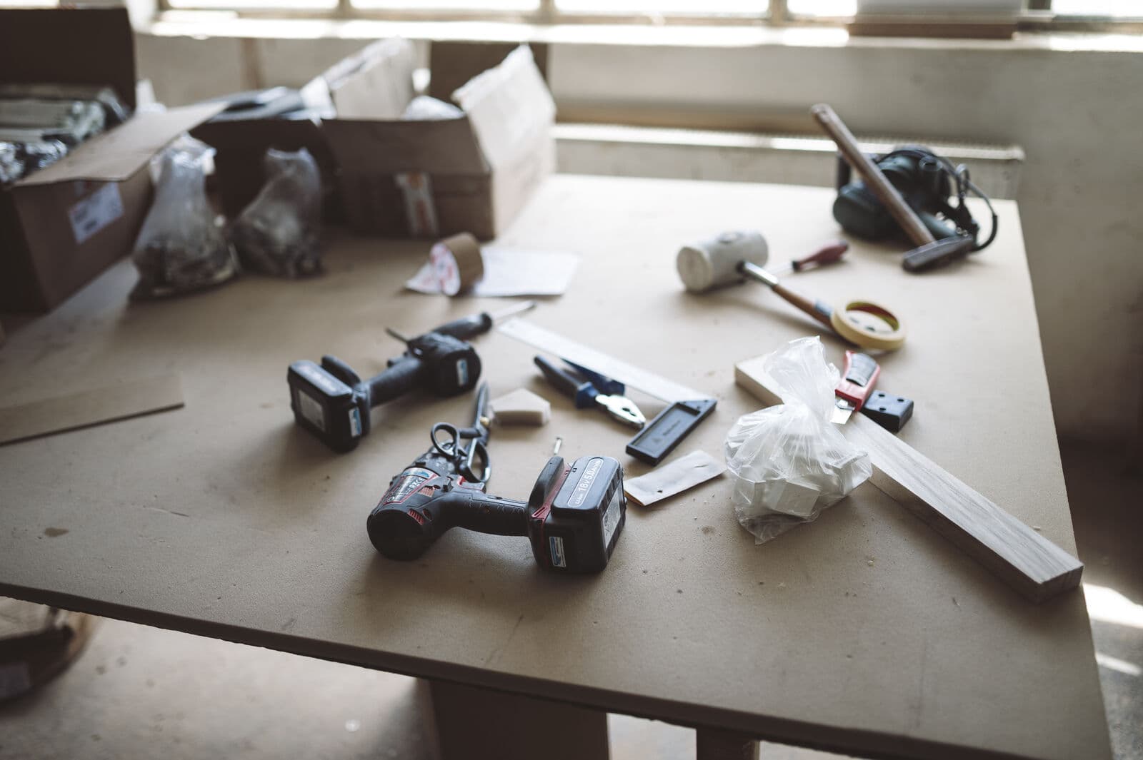 Cordless drills and hand tools on a workshop workbench.