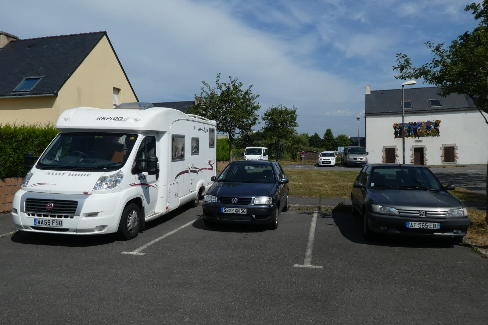 White Class C motorhome parked in a paved lot.